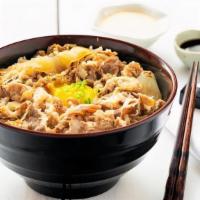 Gyudon · Bowl of rice topped with beef and onion and row yolk on it