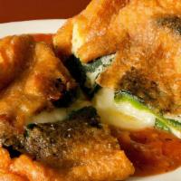 Chiles Rellenos · Delicious roasted pasilla pepper, filled asadero cheese, covered in egg batter and topped wi...