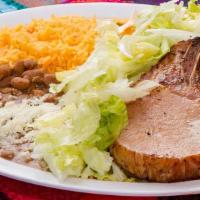 Chuletas Ahumadas · Order of two delicious smoked pork chops served with rice and beans the side of guacamole, s...
