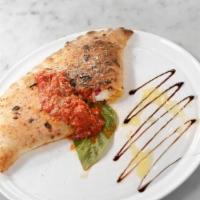 Spicy Sausage Calzone · Spicy sausage, fresh provolone, bell peppers, red onions, marinara, basil, parmesan, and gar...