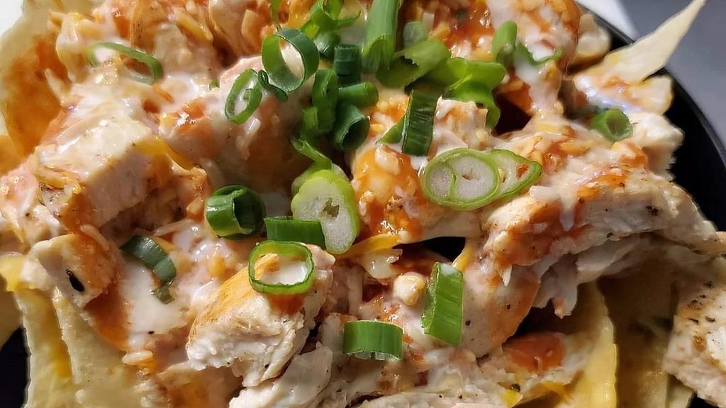  The Buff Chick Notchos · Corn Tortilla chips with our cerveza queso, grilled chicken, buffalo sauce, green onions & creme fraiche.