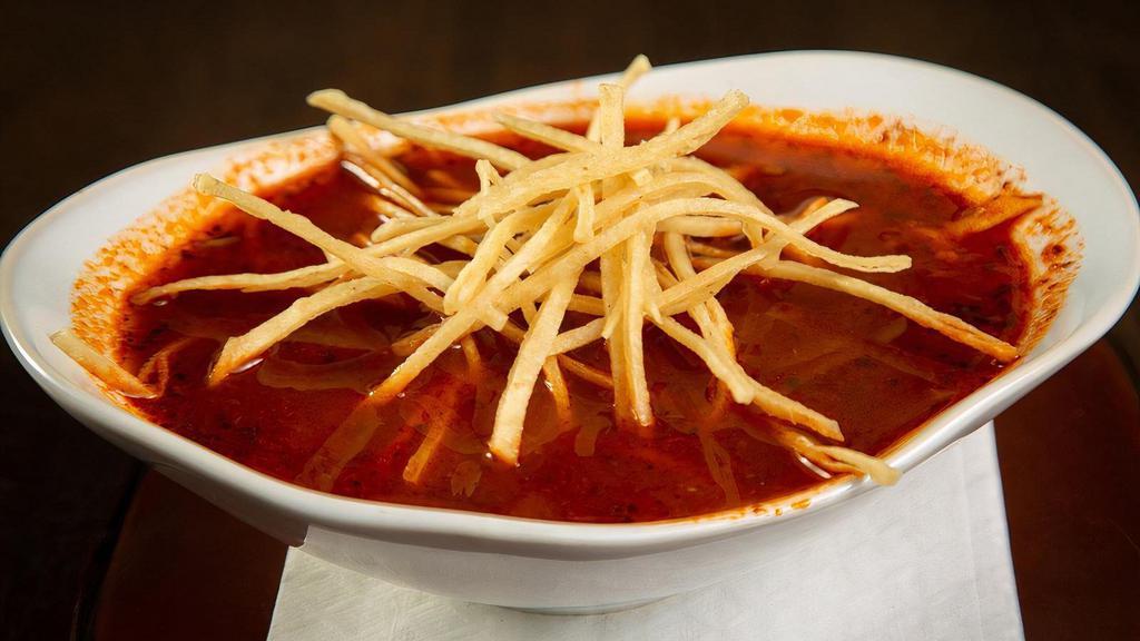 Tortilla Soup · Chile Ancho Broth, Tomatoes, Pulled Chicken, Grilled Corn, Mexican Cheese Blend, Crispy Tortillas Strips
