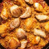 Meaty Paella · House-made chorizo, chicken confit, crispy jamon, roasted peppers, peas, & saffron rice.