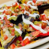 Classic Nachos · Tri-color chips filled with black beans, jalapeños, smothered in Jack Cheddar cheese and top...