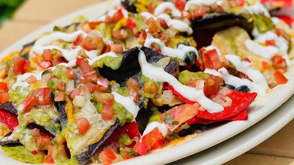 Classic Nachos · Tri-color chips filled with black beans, jalapeños, smothered in Jack Cheddar cheese and topped with pico de gallo. Finished with tomatillo sauce and sour cream drizzle.