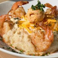 Shrimp & Grits · Our perfectly seasoned grits smothered in jack cheddar cheese and topped with Cajun Shrimp