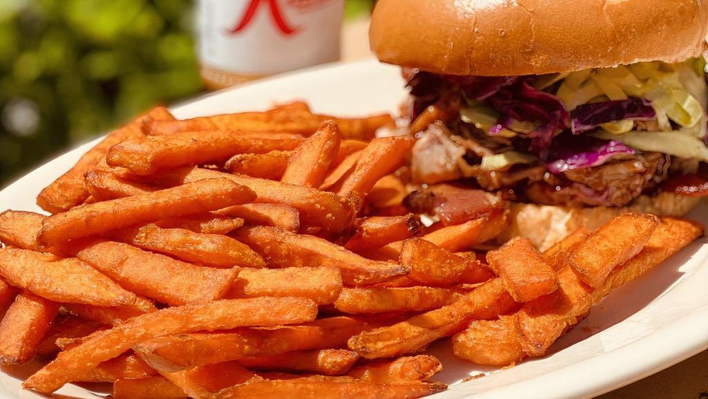 Bbq Pulled Pork Sandwich · Marinated pork tossed in bbq sauce topped with coleslaw and applewood bacon. Served on a brioche bun. Served with  fries or sweet potato fries.
