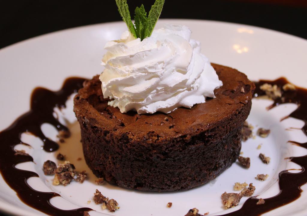 Lava Flow Brownie · Chocolate brownie with chocolate lava pouring from the center served warm with a scoop of vanilla bean ice cream topped with caramel sauce and chocolate chips.