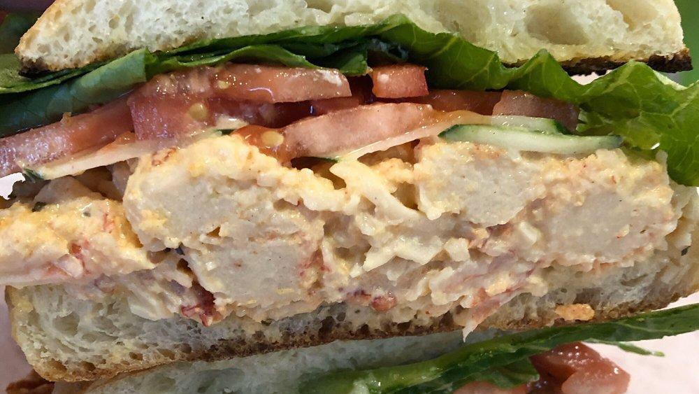 Lobster Sandwich · Most popular. Lobster and crab concoction on a ciabatta roll, garlic cheese spread, lettuce, tomatoes, and cucumber.