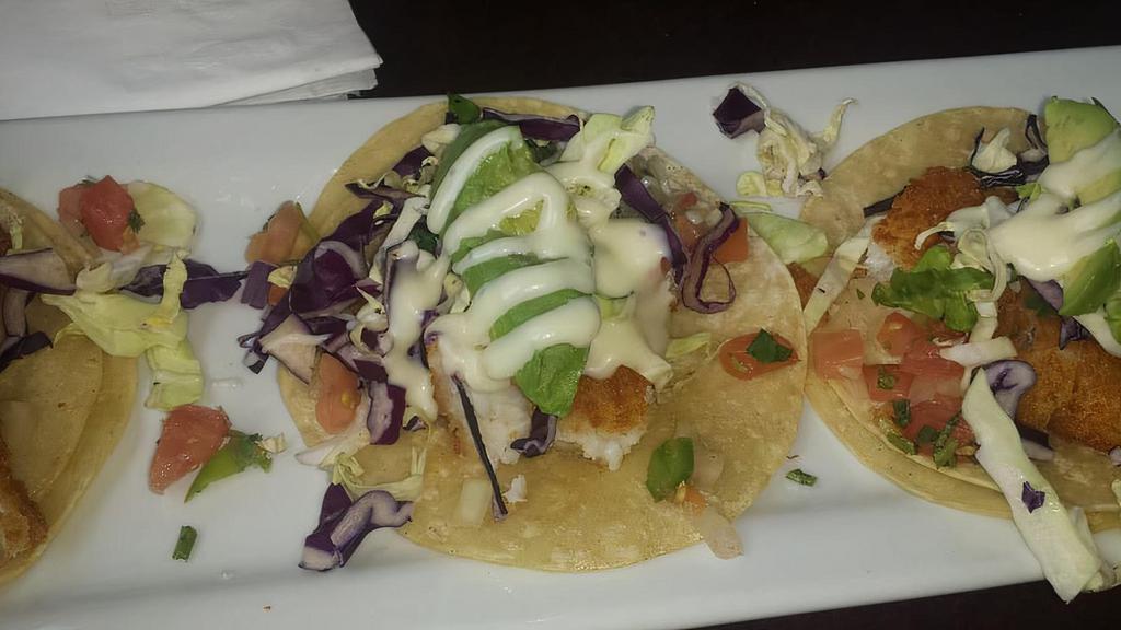 Fish Tacos · Two tortillas filled with lightly battered or grilled fish, and topped with a tangy coleslaw, pico de gallo salsa, and avocado.