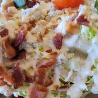 The Icy Wedge · Iced wedge of iceberg lettuce, heirloom cherry tomatoes, crumbled blue cheese, and bacon bit...