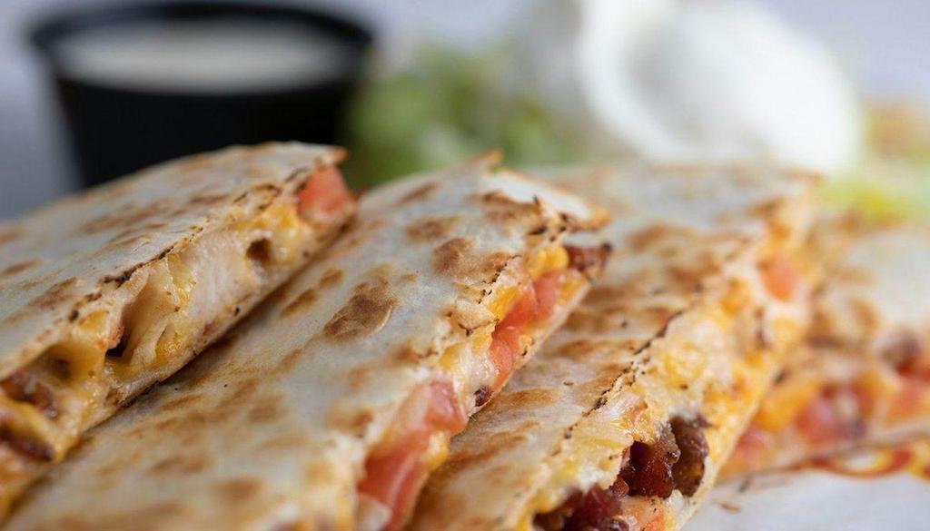 Bacon Chicken Ranch Quesadilla · Large flour tortilla, bacon, grilled shredded chicken, ranch, melted cheddar and pepper jack cheese. Served with pico, sour cream, and guacamole.