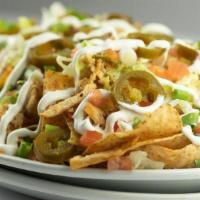 Chicken Cheese Nachos · Freshly fried tortilla chips layered with our own queso sauce, cheddar, and pepper jack chee...