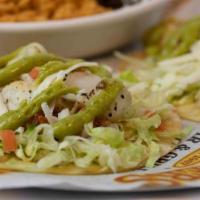 Grilled Fish Tacos · Two street-style soft corn tortilla tacos with grilled fish, avocado aioli, queso fresco, pi...