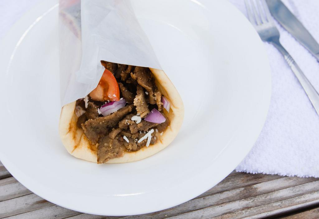 Original Gyro · Soft and warm pita bread, misted in olive oil, wrapped around seasoned beef and lamb mixture carved on a vertical rotisserie, with our housemade tzatziki sauce (Greek yogurt spread), diced tomato, chopped red onion, and crumbled feta cheese.