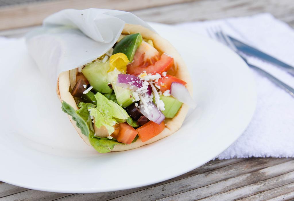 Veggie Gyro · Soft and warm pita bread, misted in olive oil, wrapped around fresh romaine lettuce, cucumber, green bell pepper, diced tomato, red onion, kalamata olives, pepperoncini, and crumbled feta cheese, with your choice of our house made tzatziki sauce (Greek yogurt spread) or hummus.