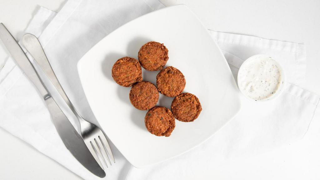 Falafel Side · A serving of six deep fried dough balls made with mashed chickpeas, olive oil, and spices, with a side of tzatziki sauce (Greek yogurt spread).
