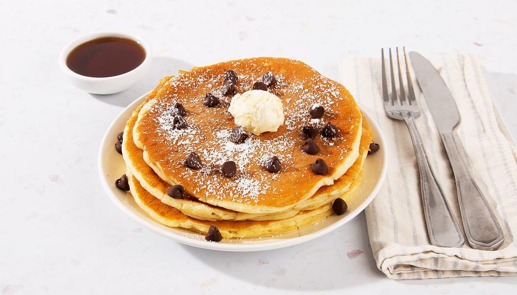 Chocolate Chip Pancakes · Three fluffy buttermilk pancakes topped with rich chocolate chips, and served with maple syrup and powdered sugar.