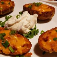 Potato Skins · Loaded with Tillamook Cheddar Cheese, bacon, & green onions. Served with sour cream.