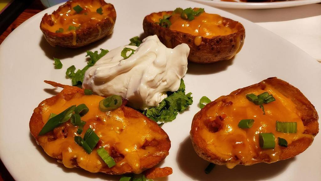 Potato Skins · Loaded with Tillamook Cheddar Cheese, bacon, & green onions. Served with sour cream.