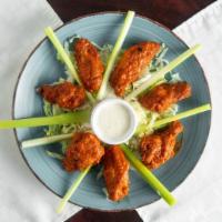 Buffalo Wings · Buffalo wings roasted and smothered with peppers, garlic and BBQ sauce.