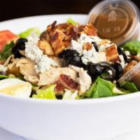 Cobb · Sliced chicken breast, crumbled bleu cheese, bacon, olives, and tomatoes on a bed of vegetab...