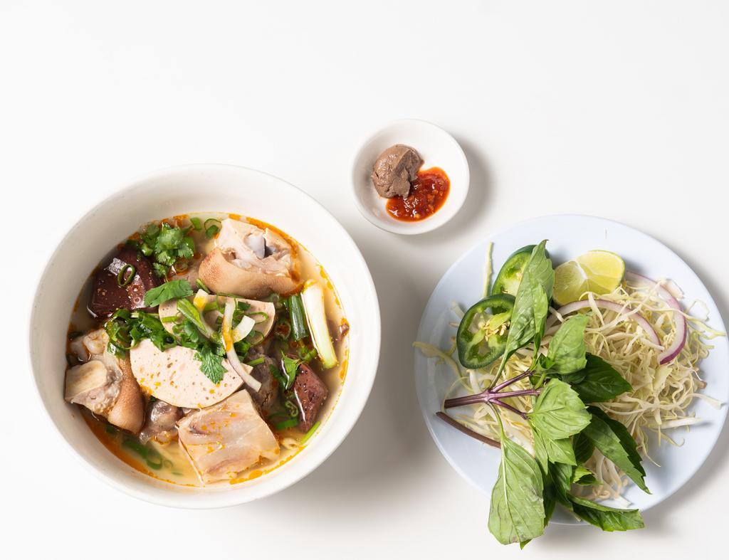 Bún Bò Huế · Spicy noodle soup with beef shanks, pork hock pork blood, Vietnamese pork ham (chả lụa) & veggies. Soup base: beef & pork.