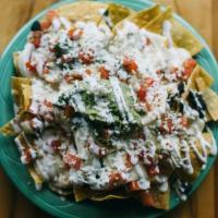 Nachos · Made with your choice of meat or veggies, black beans, cheese, guacamole, crema Mexicana, an...