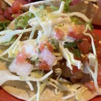 Taco-Pescado · breaded and fried white fish on two corn tortillas topped with salsa fresca, cabbage, pickle...