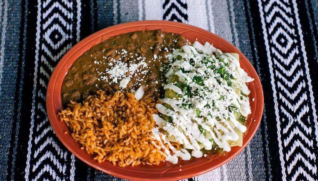 Enchiladas Suizas · 3 chicken enchiladas topped with salsa verde, crema Mexicana, onions, cilantro, and queso Fresca, served with rice and beans.