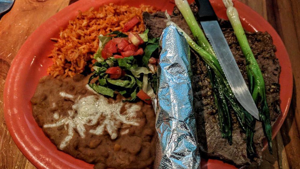 Carne Asada · Thinly sliced marinated steaks topped with chimichurri sauce and grilled green onion, served with rice, beans, and your choice of flour or corn tortillas.