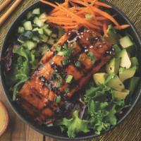 Honey Sriracha Salmon Salad · A bed of mixed greens topped with cucumbers, shredded carrots, green onions, sesame seeds, a...