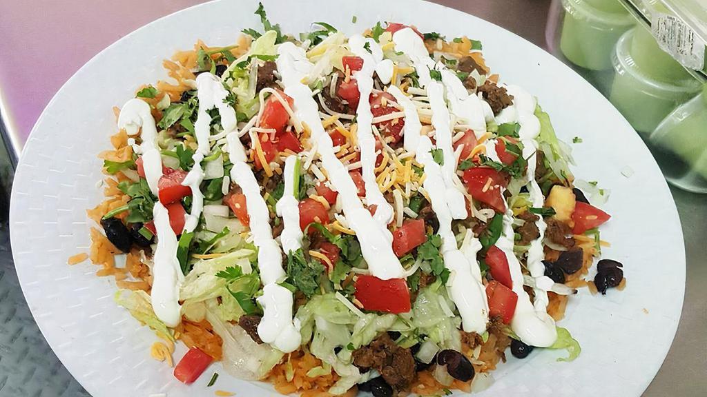 Burrito Bowl · Rice, beans, choice of meat, onions, cilantro, lettuce, tomato, cheese and sour cream served in a bowl.