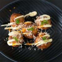 Takoyaki · Crispy octopus balls served with chipotle mayo and eel sauce garnished with bonito flakes.