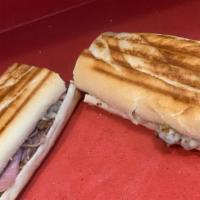 Cubano · Cuban style sandwich layered with roast pork, ham, pickle and melted provolone cheese with a...