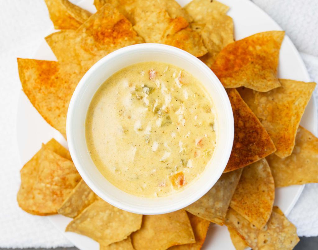 Chile Con Queso Dip · Delicious combination of two types of cheese, blended with Anaheim and jalapeño peppers, tomatoes, onions served with fresh made chips.
