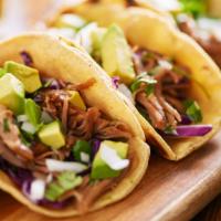 Carnitas Street Taco · Flavorful carnitas (pork), lettuce, and creamy cheese sitting on a fresh made tortilla.