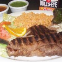 Carne Asada Plate · Grilled T-bone steak. Served with beans, rice, lettuce, tomato, roasted jalapeno and tortill...