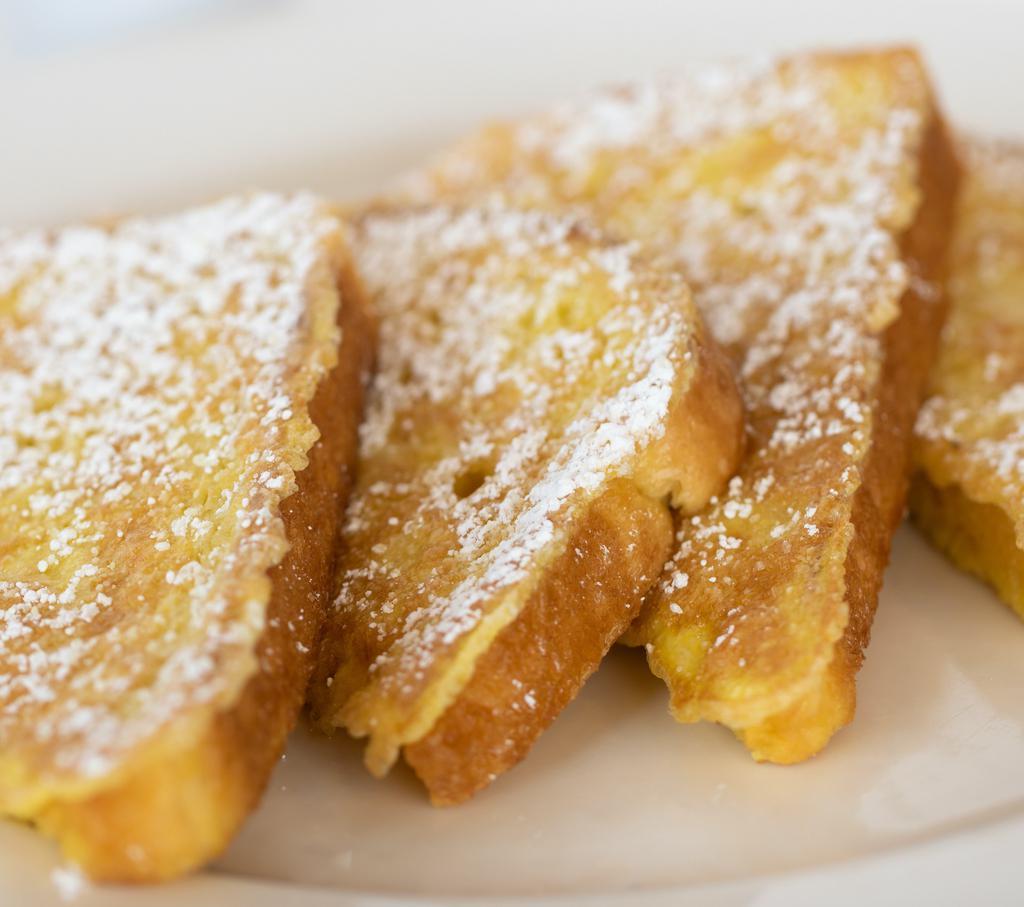 Sourdough French Toast · Golden brown, light and fluffy. Dusted with powdered sugar. Served with whipped butter and preserves. 910 cal.