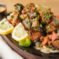 Lamb Boti Kabob (Bone-Less) · Gluten-free. Marinated lamb cubes barbecued in clay oven & served on sizzler with masala sau...