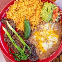 Carne Asada · Slices of flank steak, served with rice, beans guacamole, lettuce, tomatoes, green onions, a...