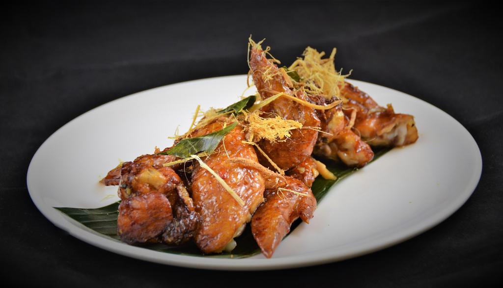 Peek Kai * ปีกไก่ทอด · Signature wing chicken wings marinated in fish sauce, deep fried, tossed in caramelized garlic sauce.