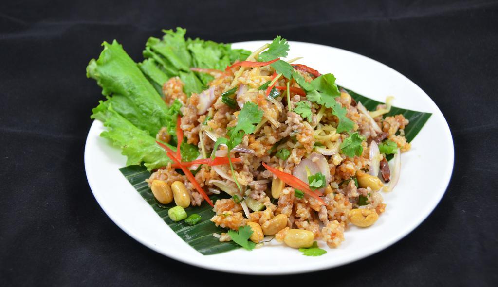 Nam Kao Tod* (Crispy Rice & Pork Salad) · Crispy curry rice tossed with pork sausage, lime sauce, ginger, roasted chili, peanuts, onions and cilantro.