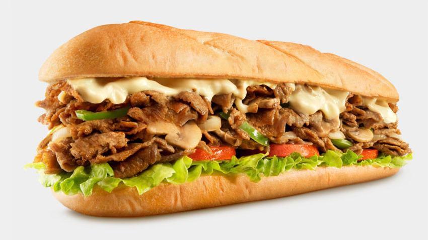 Philly Cheesesteak · Sliced ribeye steak, melted nacho cheese, grilled onions, roasted peppers, sautéed mushrooms on a hoagie roll.