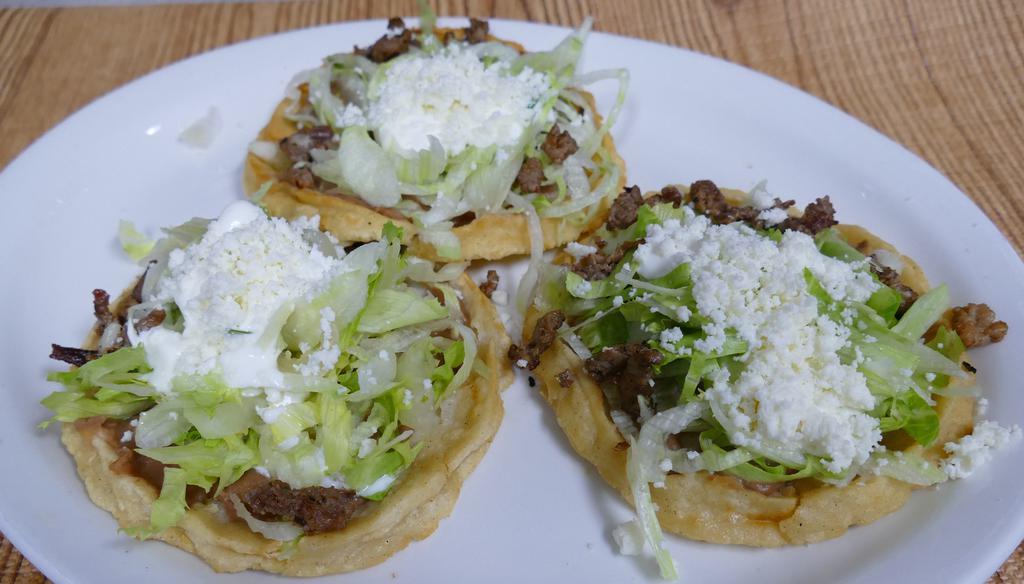 Sope (Single One) · Each thick hand-made tortilla fried and topped with brown beans, lettuce, fresh Mexican cheese, and sour cream. With your choice of meat: steak, chicken, marinated pork, chorizo, carnitas,  or lengua.