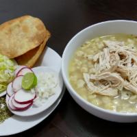 Pozole · The chicken soup comes with hominy accompanied with a side of chopped onion limes, lettuce, ...