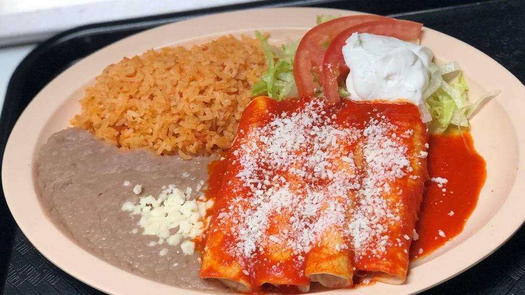 Enchiladas Suizas · Authentic enchiladas with filling prepared with sauce of fresh mexican tomatillos, green peppers, onions, avocado slices and spices. Topped with sour cream.