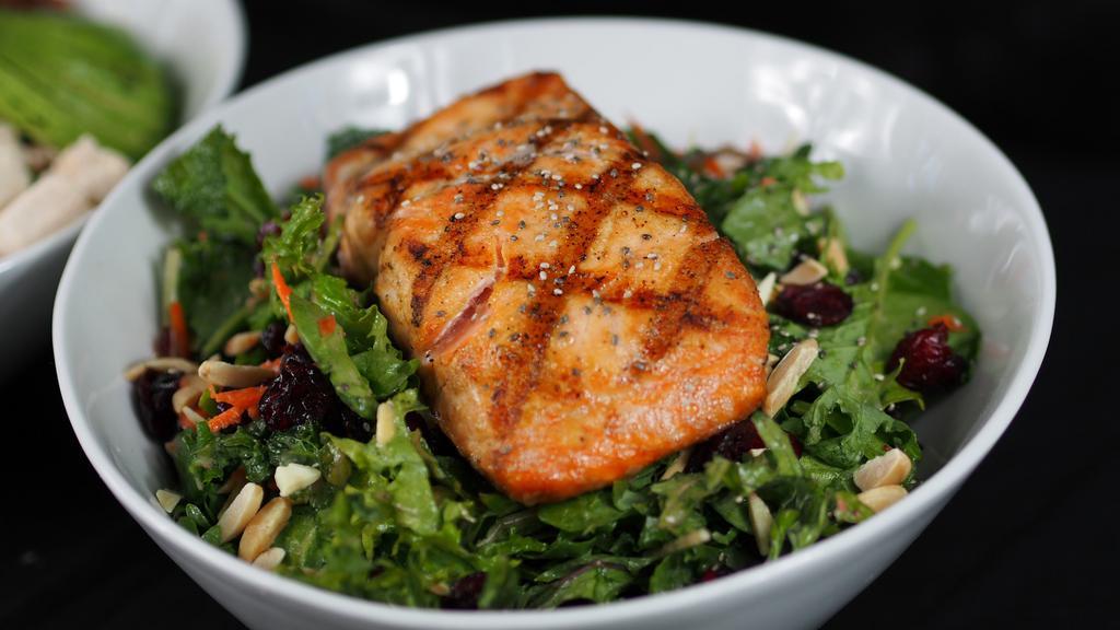 Salmon Kale Salad · Spinach, kale, salmon, dried cranberries, chia seeds, almonds and balsamic vinaigrette. Gluten-free.