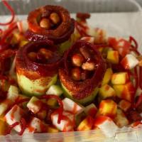 Pepinos Locos · Cucumbers with chamoy and tajin rim filled with tamarind candies, japanese peanuts and chamo...