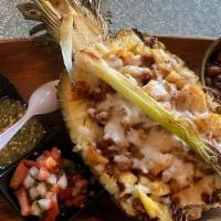 *Piña Al Pastor · Half pineapple that's fire grilled on mesquite and filled with al pastor meat. Topped with m...